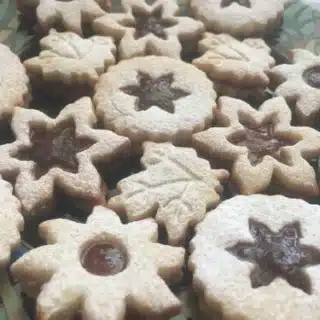 Linzer cookies of various shapes filled with apricot jam