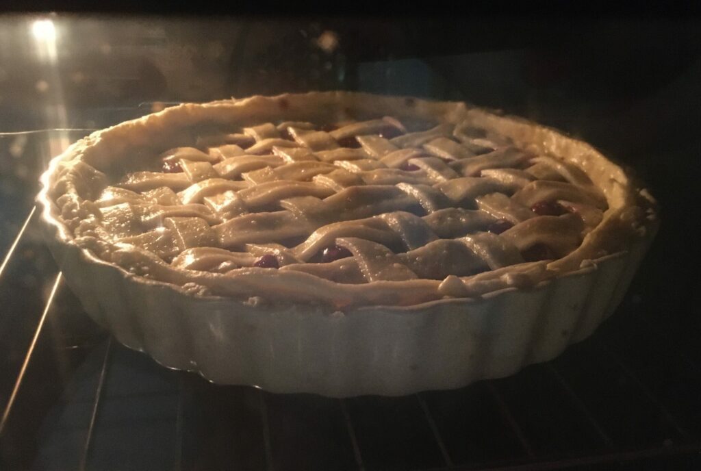 A oie with lattice on top baking in the oven.