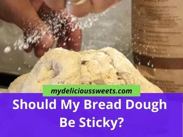 A bread dough and a hand that sprinkles flour.