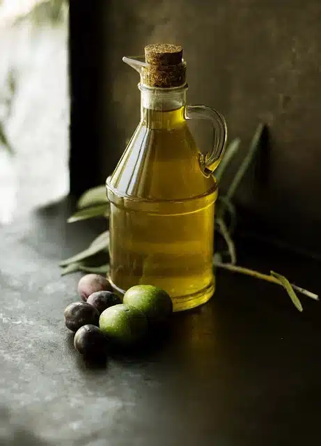 Olive oil in bottle with fresh olives.