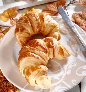 Two croissants and a knife on a plate