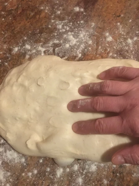A hand on a bread dough.